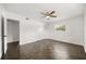 An empty bedroom features a ceiling fan, closet and a large window, with hard wood floors at 1505 N Lake Mirror Nw Dr, Winter Haven, FL 33881