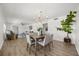Bright dining area with a modern chandelier, wood table, and views into the adjacent living room at 1505 N Lake Mirror Nw Dr, Winter Haven, FL 33881