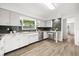 Well-lit kitchen with modern appliances, white cabinetry, a breakfast bar, and gray subway tile at 1505 N Lake Mirror Nw Dr, Winter Haven, FL 33881