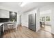 Modern kitchen featuring stainless steel appliances, white cabinets, breakfast bar, and access to dining area at 1505 N Lake Mirror Nw Dr, Winter Haven, FL 33881