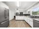 Bright kitchen featuring stainless steel appliances, white cabinets, and gray subway tile backsplash at 1505 N Lake Mirror Nw Dr, Winter Haven, FL 33881
