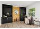 Cozy living room with built-in shelving, wood accent wall, and a comfortable chair near a window at 1505 N Lake Mirror Nw Dr, Winter Haven, FL 33881