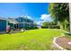 Expansive backyard featuring lush green lawn, landscaping, and an outdoor dining area at 1609 E Kaley Ave, Orlando, FL 32806