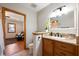 Well-lit bathroom featuring granite countertops, wooden cabinets and view to living room at 1609 E Kaley Ave, Orlando, FL 32806