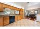 Open-concept kitchen with granite countertops, wood cabinets, and black appliances offers seamless flow to dining area at 1609 E Kaley Ave, Orlando, FL 32806