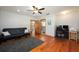 Inviting living room featuring hardwood floors, ceiling fan, and comfortable futon couch at 1609 E Kaley Ave, Orlando, FL 32806