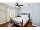 Cozy bedroom features wood floors, a ceiling fan, and a view of the outdoors through the window at 165 Scrub Jay Way, Davenport, FL 33896