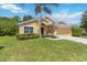 Inviting single-story home features a two-car garage, mature landscaping, and a well-maintained lawn at 165 Scrub Jay Way, Davenport, FL 33896