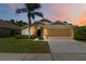 Inviting single-story home features a two-car garage, mature landscaping, and a well-maintained lawn at 165 Scrub Jay Way, Davenport, FL 33896
