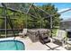 Private hot tub nestled within the screened-in lanai, surrounded by lush greenery at 165 Scrub Jay Way, Davenport, FL 33896