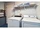 Practical laundry area featuring a washer, dryer, shelving, and utility sink at 165 Scrub Jay Way, Davenport, FL 33896