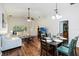 Open-concept living room with wood floors and adjacent dining area offers comfortable living at 165 Scrub Jay Way, Davenport, FL 33896