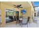 Cozy covered patio with outdoor seating, a ceiling fan, and TV for outdoor entertaining at 165 Scrub Jay Way, Davenport, FL 33896