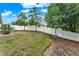 Picture of backyard featuring a white vinyl privacy fence, green grass, and mature trees at 1692 Blue Grass Blvd, Deland, FL 32724