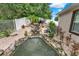 Beautiful backyard pond with waterfall feature surrounded by lush landscaping and white fencing at 1692 Blue Grass Blvd, Deland, FL 32724