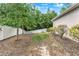 Sloping backyard featuring a white fence, trees, and partial shade at 1692 Blue Grass Blvd, Deland, FL 32724