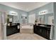 Bright bathroom featuring dual vanities, a soaking tub, and a large mirror at 1692 Blue Grass Blvd, Deland, FL 32724