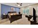 Primary bedroom with a blue accent wall, ceiling fan, and plantation shutters for a relaxing retreat at 1692 Blue Grass Blvd, Deland, FL 32724