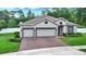 Charming home featuring a three-car garage and brick-paved driveway at 1692 Blue Grass Blvd, Deland, FL 32724
