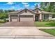 Attractive single-story home featuring a three-car garage and meticulously maintained landscaping at 1692 Blue Grass Blvd, Deland, FL 32724