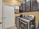 Laundry room with modern washer and dryer, upper cabinets for storage and tile floor at 1692 Blue Grass Blvd, Deland, FL 32724