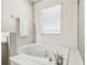 Garden tub surrounded by tile, with window view, and chrome fixtures at 1936 Westpointe Cir, Orlando, FL 32835