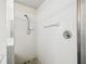 Clean white tiled shower with chrome fixtures and pebble-style flooring at 1936 Westpointe Cir, Orlando, FL 32835