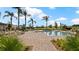 Community pool area with lounge chairs, palm trees, lush landscaping, and clear blue skies, creating a relaxing environment at 2273 White Buffalo St, Apopka, FL 32703