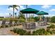 Inviting outdoor lounge area featuring comfortable seating under umbrellas, surrounded by lush greenery and palm trees at 2273 White Buffalo St, Apopka, FL 32703
