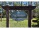 Community sign that reads Pine Meadows Conservation Area with trees and native plants in the background at 2416 Cabinwood Range Way, Eustis, FL 32726