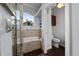 Bright bathroom with a walk-in shower, soaking tub, and wood-look tile flooring at 2638 Clarinet Dr, Orlando, FL 32837