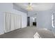 Spacious bedroom with a ceiling fan, a closet with a curtain, and a large mirror at 2719 Candlewood Ct, Apopka, FL 32703