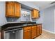 Kitchen with stainless steel dishwasher, wood cabinets and black countertops at 2719 Candlewood Ct, Apopka, FL 32703