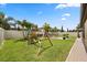 Grassy backyard offering a playset, brick pavers, firepit and ample space for outdoor activities at 2896 Matera Dr, St Cloud, FL 34771