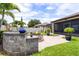 Backyard featuring a custom fire pit, lush landscaping, stone pavers and large lawn for outdoor enjoyment at 2896 Matera Dr, St Cloud, FL 34771