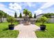 Inviting backyard oasis with a custom fire pit, manicured landscaping, and lush green grass for relaxation at 2896 Matera Dr, St Cloud, FL 34771