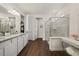 Bright bathroom boasting wood flooring, double vanity, glass shower, and walk in closet at 2896 Matera Dr, St Cloud, FL 34771