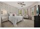 Stylish bedroom with a decorative accent wall, plush bedding, and abundant natural light from large windows at 2896 Matera Dr, St Cloud, FL 34771