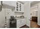 Butlers pantry with granite countertop, custom cabinets, wine cooler, and tile flooring at 2896 Matera Dr, St Cloud, FL 34771