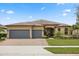 Charming one-story home featuring a three-car garage, brick driveway and meticulously landscaped front yard at 2896 Matera Dr, St Cloud, FL 34771
