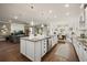 Open concept kitchen with island, stainless appliances, adjacent to the living and dining areas at 2896 Matera Dr, St Cloud, FL 34771