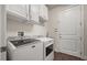 Convenient laundry room with modern appliances, white cabinetry, and wood flooring at 2896 Matera Dr, St Cloud, FL 34771