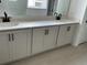 Bathroom vanity with dual sinks, white cabinets, black hardware, and modern fixtures at 2971 Embark Trail, St Cloud, FL 34771