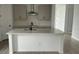 Modern kitchen with gray cabinets, a stainless range hood, white quartz countertops, and a central island at 2971 Embark Trail, St Cloud, FL 34771