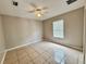 Neutral bedroom featuring tile flooring, a fan, and a bright window at 306 Snook Way, Kissimmee, FL 34759