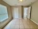 Cozy bedroom with tile flooring, ceiling fan, window with blinds, and closet at 306 Snook Way, Kissimmee, FL 34759
