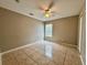 Bedroom featuring tile flooring, a ceiling fan, and natural light from the window at 306 Snook Way, Kissimmee, FL 34759