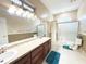 Spacious bathroom featuring double sinks, tile floors, separate stall shower, and a linen closet at 3100 Pine Needle Trl, Kissimmee, FL 34746