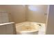 A relaxing, clean bathtub sits in the corner of a neutral-toned bathroom at 3100 Pine Needle Trl, Kissimmee, FL 34746