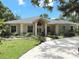 Inviting single-story home with a grand entrance, mature trees, and well-manicured lawn at 3100 Pine Needle Trl, Kissimmee, FL 34746